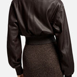 Back view of a dark brown Grained Leather Bomber Jacket by Ralph Lauren Collection, featuring a ribbed knit collar and cuffs, worn over a brown ribbed skirt.
