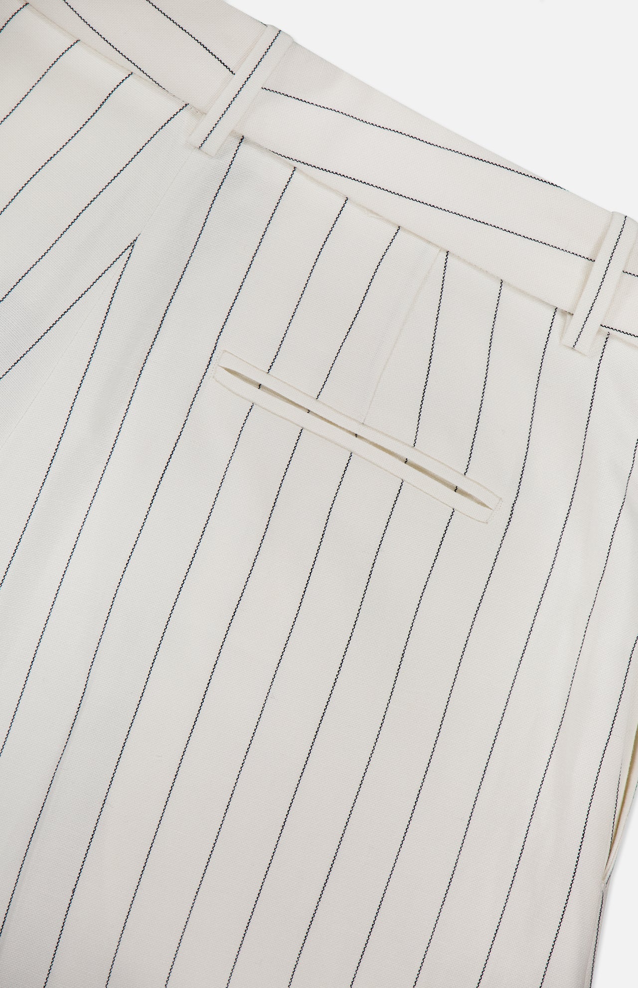 Close-up of the back of the Harlo Pleated Stripe Suit Pants by RALPH LAUREN COLLECTION, featuring off-white cotton-blend fabric with thin black pinstripes, a single welt pocket, and belt loops.