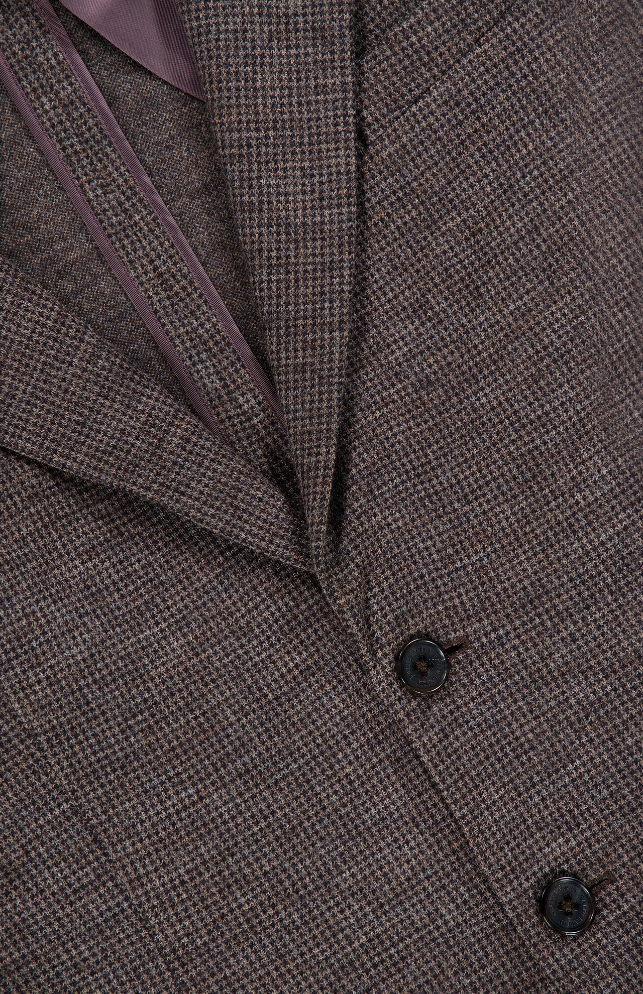 Close-up of the RALPH LAUREN COLLECTION Jersey Knit Blazer, Italian-made in brown tweed with a subtle check pattern, featuring two black buttons and a glimpse of the purple inner lining.