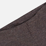 A close-up view of the brown textured fabric from the RALPH LAUREN COLLECTION Jersey Knit Standard Straight Pants, displayed diagonally against a white background.