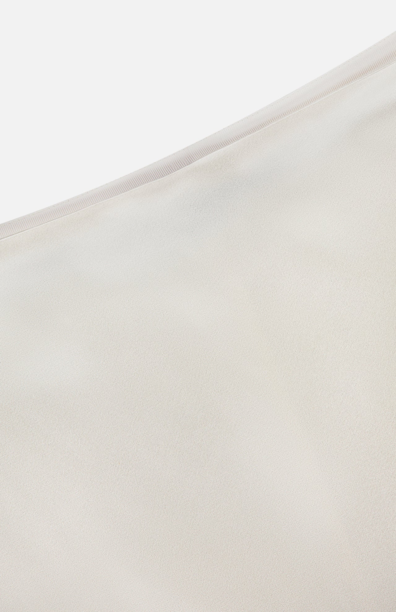 A close-up of light beige satin with a smooth, lustrous texture and seam detail—perfect for the Masina Lux Satin Maxi Skirt by RALPH LAUREN COLLECTION.