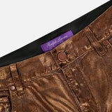 Close-up of Mercer Cotton Denim Full Length Wide Pant by RALPH LAUREN COLLECTION, featuring metallic bronze finish, button closure, belt loops, and a purple label inside the waistband, highlighting the brand’s signature wide-leg denim style.