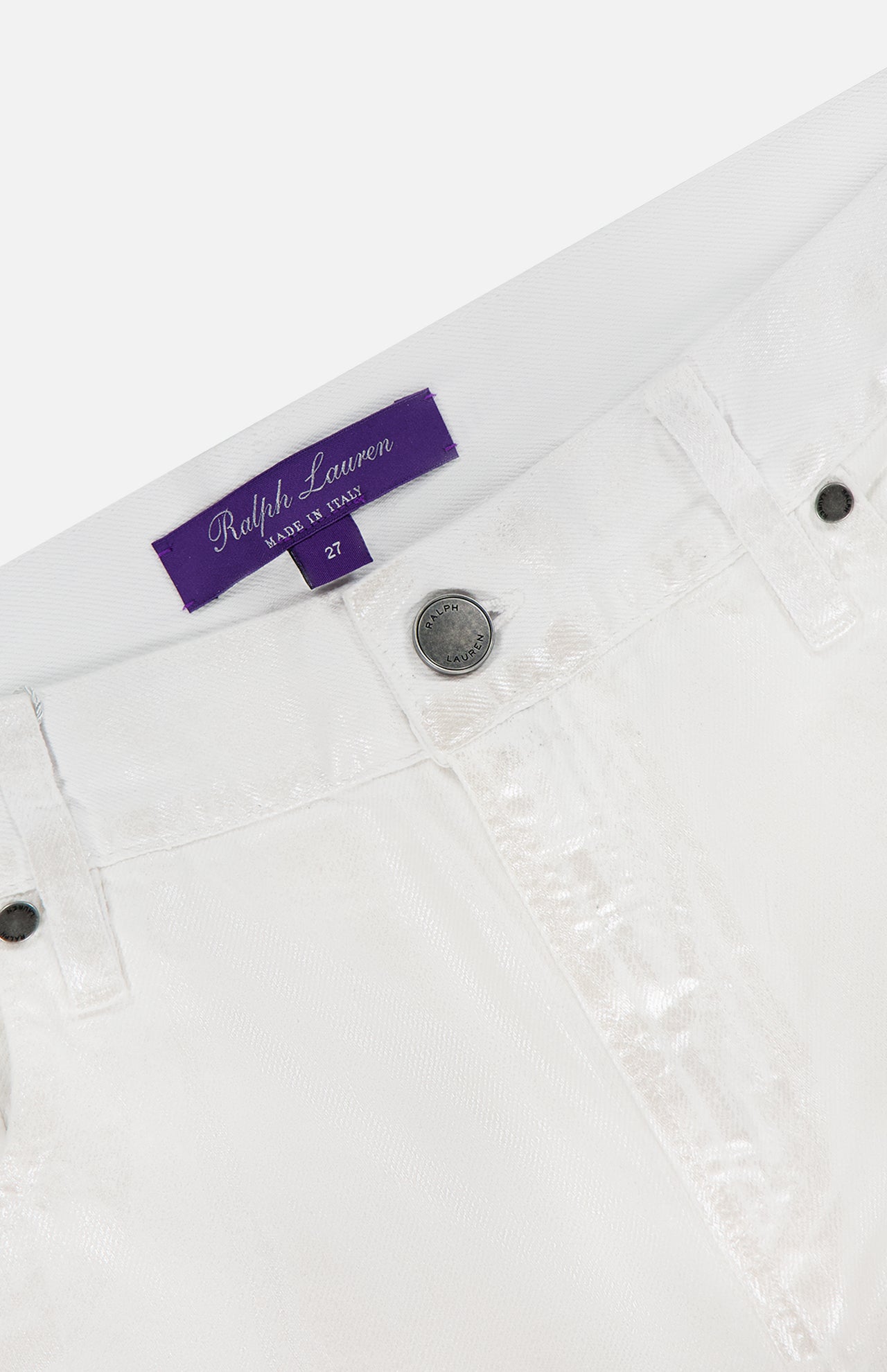 Close-up of the waistband on Mercer Wide Leg Jeans by RALPH LAUREN COLLECTION, in white eco stone-washed denim, featuring a silver button, belt loops, and a purple Ralph Lauren label stitched inside.