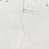 A close-up of white Mercer Wide Leg Jeans from RALPH LAUREN COLLECTION features a partially open zipper and button, highlighting the waistband, pockets, and an inside back label bearing the brand’s name.