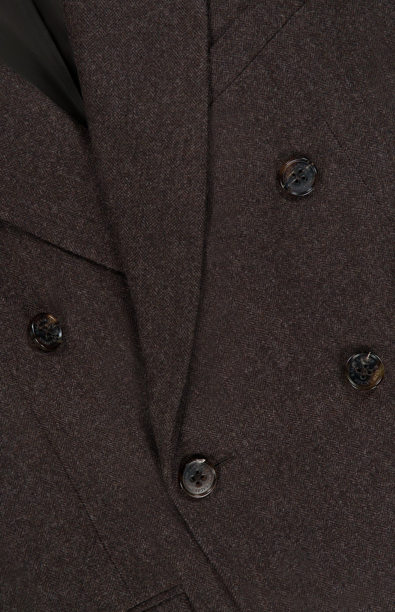 Close-up of the RALPH LAUREN COLLECTION Mini Herringbone Blazer, highlighting its dark brown wool construction, six black and brown marbled buttons, and textured herringbone fabric.