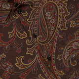 Close-up of a brown Paisley Collared Long Sleeve Blouse by RALPH LAUREN COLLECTION, featuring a paisley pattern in shades of red, yellow, and beige. Several black buttons line the front, making this blouse a versatile addition to your fall wardrobe.