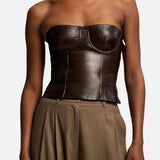 A dark brown Ralph Lauren Collection Plonge Leather Strapless Bandeau Top worn with high-waisted trousers.