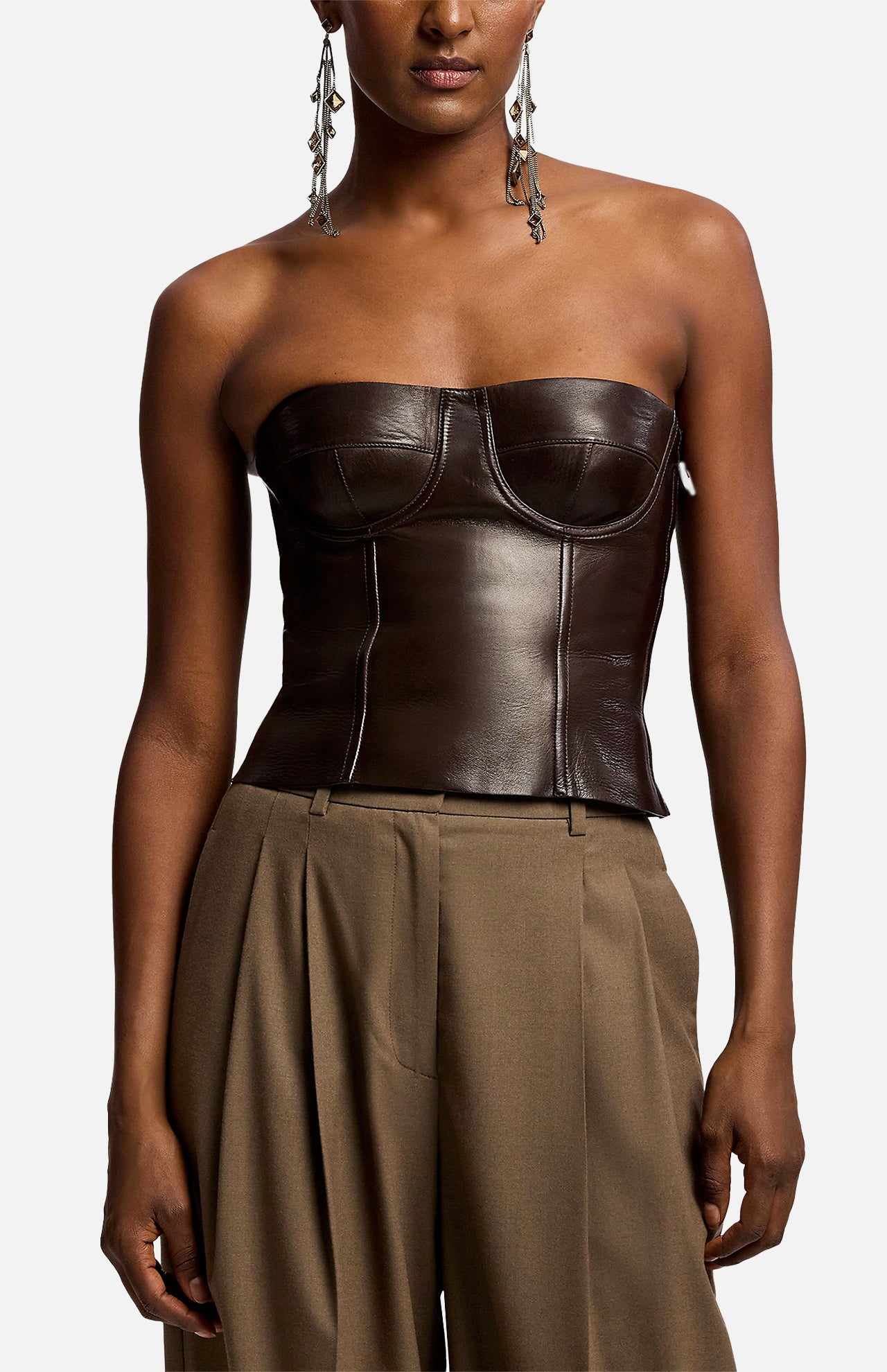 A dark brown Ralph Lauren Collection Plonge Leather Strapless Bandeau Top worn with high-waisted trousers.