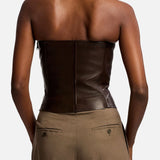 A person viewed from behind, wearing a dark brown Ralph Lauren Collection Plonge Leather Strapless Bandeau Top and tan trousers.