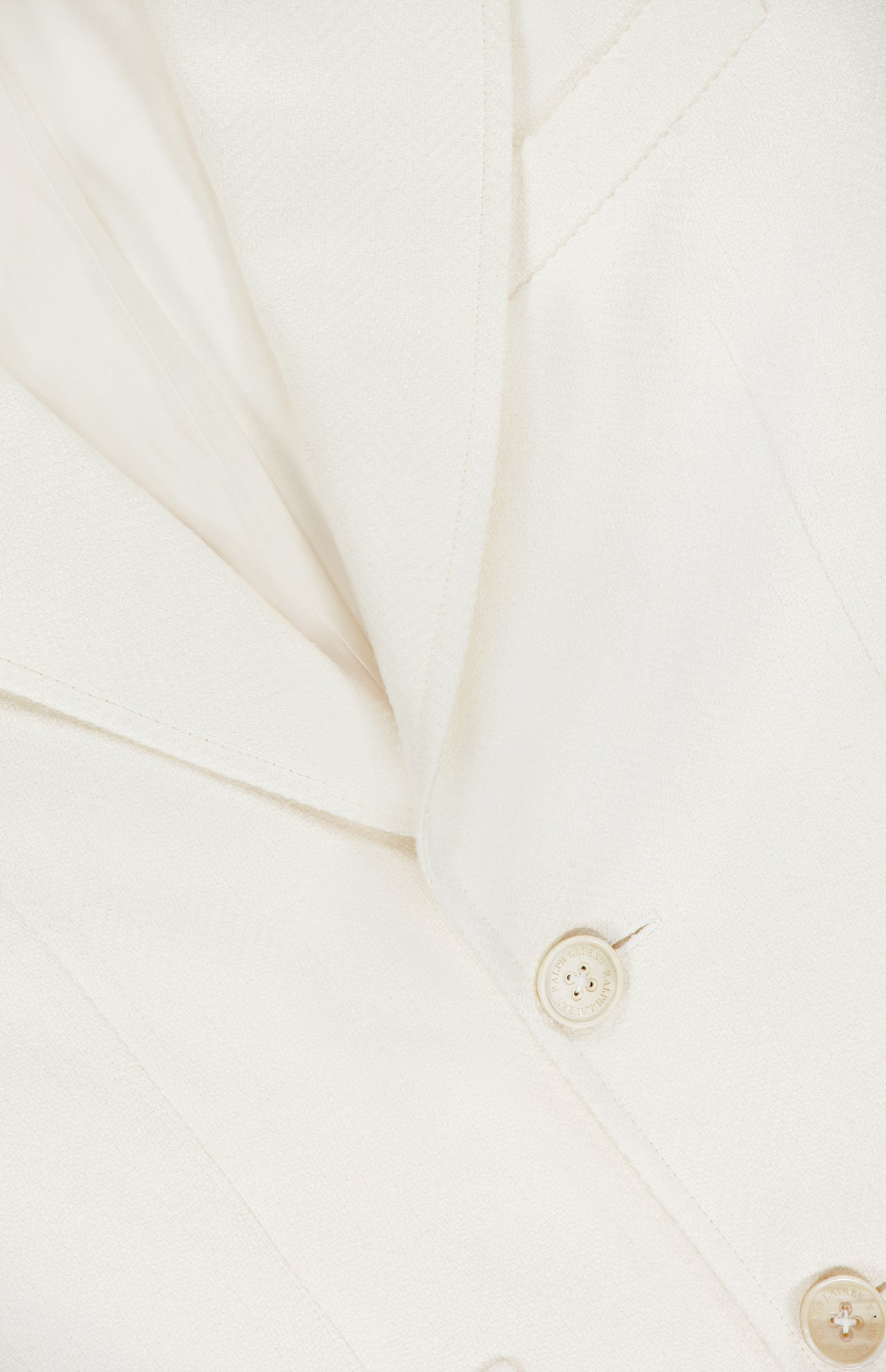 Close-up of the Preston Herringbone Tweed Blazer by RALPH LAUREN COLLECTION, highlighting the soft, textured fabric, lapel, two cream-colored buttons, and part of the collar.