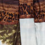 The Scenic Silk Twill Pencil Skirt by RALPH LAUREN COLLECTION showcases a luxurious blend of leopard print, ornate brown trim, and a scenic landscape with trees and sky on lustrous silk twill fabric, expertly crafted in Italy.