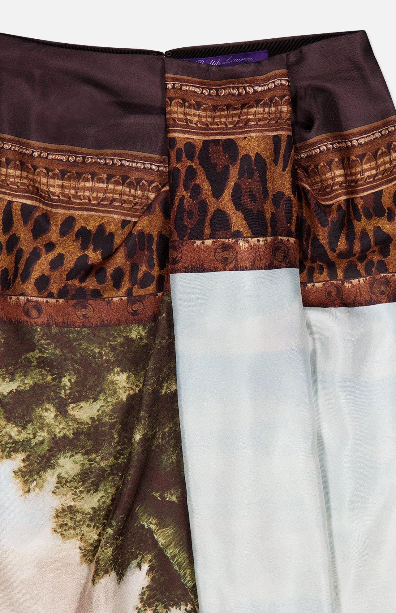 The Scenic Silk Twill Pencil Skirt by RALPH LAUREN COLLECTION showcases a luxurious blend of leopard print, ornate brown trim, and a scenic landscape with trees and sky on lustrous silk twill fabric, expertly crafted in Italy.