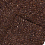 Close-up of the Tweed Ankle Pencil Skirt by RALPH LAUREN COLLECTION, highlighting the brown tweed fabric’s textured weave, visible stitching, and subtle color variations—evoking the timeless elegance of classic tailored skirts.