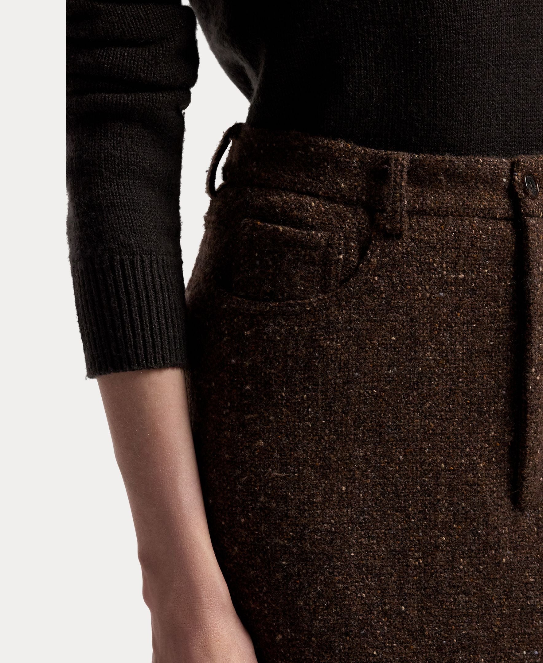 A person wearing a black long-sleeve top and the RALPH LAUREN COLLECTION Tweed Ankle Pencil Skirt. Only the torso and left arm are visible against a plain light background.