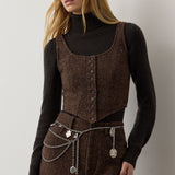 A brown RALPH LAUREN COLLECTION Tweed Scoop Neck Vest worn over a dark brown turtleneck sweater with a matching tweed skirt featuring a silver chain belt.