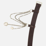 The Washed Calfskin Belt by RALPH LAUREN COLLECTION features brown full-grain leather, a silver buckle, bold chain detail, and two charms—perfect for making a statement with any outfit.