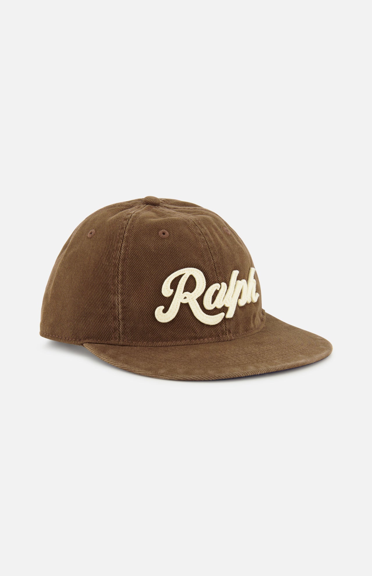 A cotton twill baseball cap from RALPH LAUREN POLO, featuring a curved brim and “Ralph” embroidered in large cream-colored script across the front, classic logo embroidery details, and an adjustable leather strap at the back.