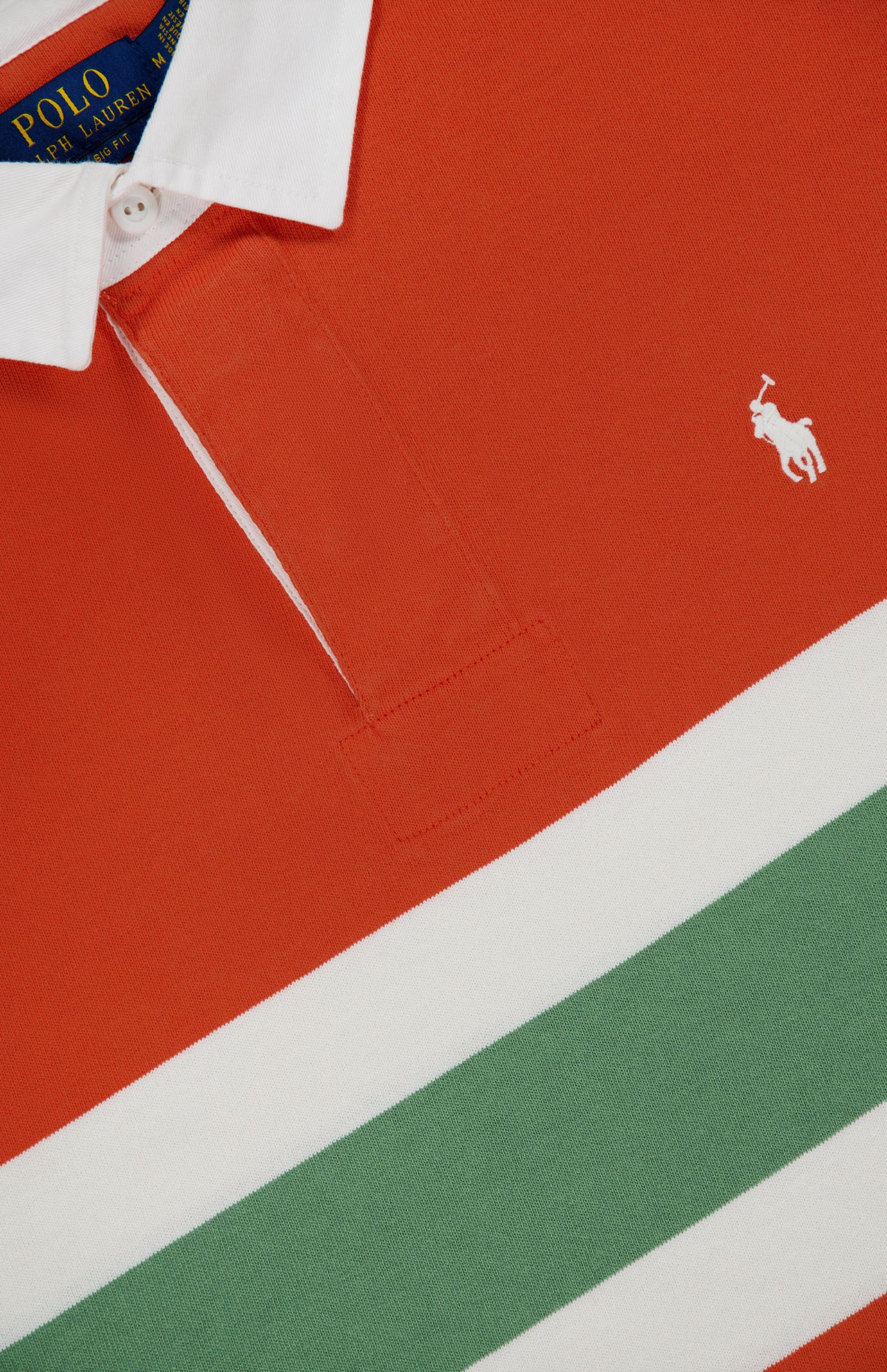 Close-up of the Red Rocks Novelty Graphic Rugby Polo Shirt by RALPH LAUREN POLO, featuring bold red, white, and green stripes, an oversized fit, a crisp white collar, and the brand’s signature embroidered Pony logo in white.
