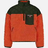 The Shaggy 1/2 Zip Polo Sport Mockneck Sweater by RALPH LAUREN POLO is a unisex fleece pullover featuring a textured orange sherpa body with olive green quilted fabric on the shoulders, collar, and chest pocket. This color-blocked half-zip design is completed with a zippered chest pocket highlighted by the distinctive Polo Sport logo.