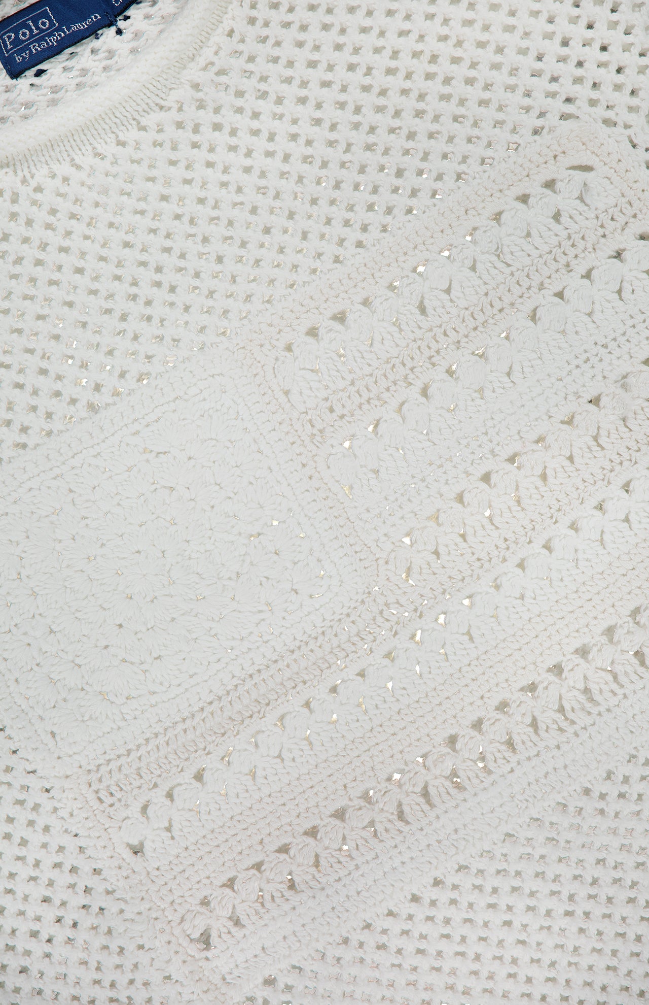 Close-up of a white Cotton Blend Long Sleeve Pullover Sweater with an intricate crochet pattern and a partially visible RALPH LAUREN POLO label at the top left.