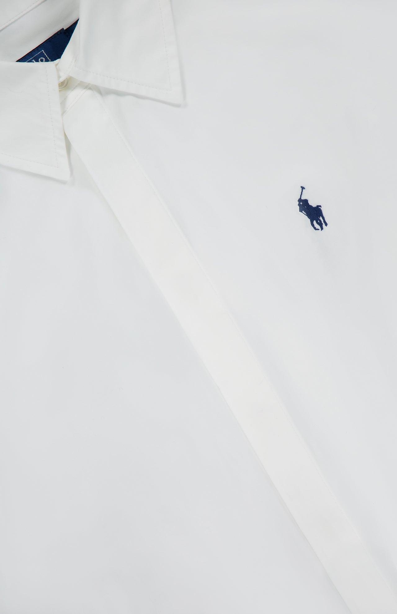 A close-up of the RALPH LAUREN POLO Cotton Collared Long Sleeve Dress, neatly buttoned and laid flat, showcases its polished yet casual style and features a blue embroidered polo player logo on the chest.