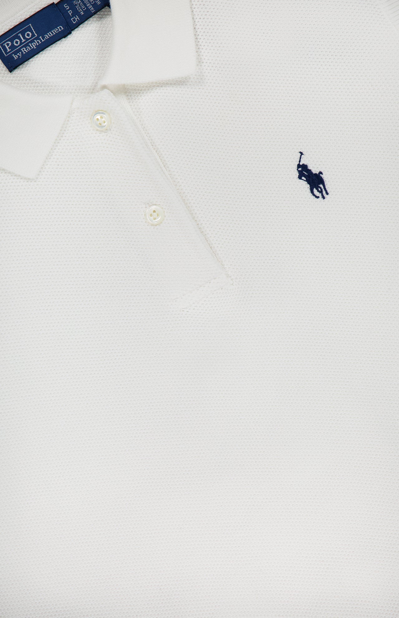 A close-up of the RALPH LAUREN POLO Cotton Sleeveless Polo Pullover Sweater, featuring a white collared design, two buttons, and a small navy blue embroidered pony logo on the chest with the label slightly visible at the top.