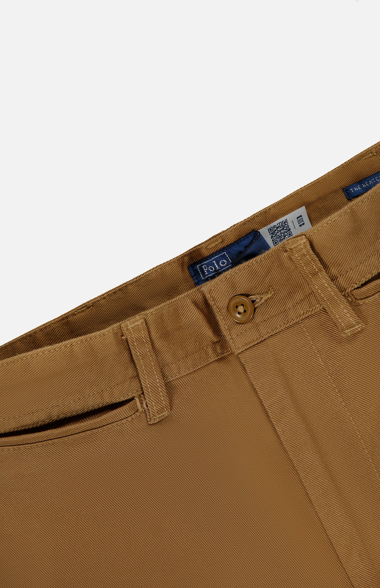 Close-up of tan Cotton Twill Flare Pants featuring belt loops, a button closure, zipper fly, and a visible RALPH LAUREN POLO brand label inside the waistband.