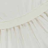 Close-up of a white knit bodice attached to an off-white pleated skirt in Italian carded-wool on a Ralph Lauren Polo Crepe Woven Turtleneck A-Line Dress.