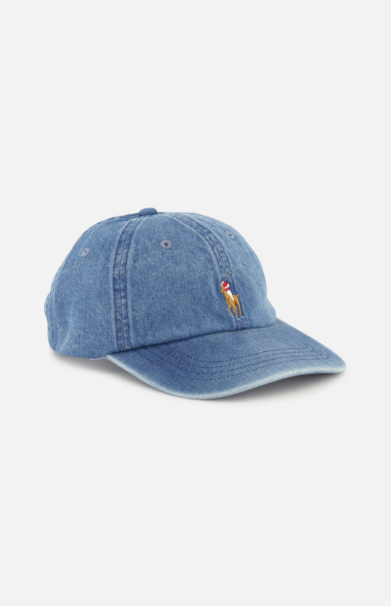 The RALPH LAUREN POLO Denim Sport Cap is crafted from light blue denim and features embroidered eyelets, along with the iconic Pony—a small polo player on horseback—stitched on the front. Designed for comfort, it includes an adjustable back strap and is displayed against a plain white background.