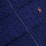 Close-up of the RALPH LAUREN POLO Wool Cashmere Sweater Vest in navy blue, showcasing a cable-knit pattern with a zipper and an orange embroidered polo player logo on the chest.