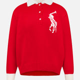 The Wool Long Sleeve Polo Collar Sweater by RALPH LAUREN POLO is a red knit sweater featuring white cuffs, a polo collar, and white buttons. Reminiscent of a classic Ralph Lauren design, it showcases an abstract animal motif in white on the left chest. Displayed against a plain white background.
