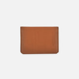 The Burnish Calf Wallet by RALPH LAUREN PURPLE LABEL is crafted from rich brown calfskin and showcases refined stitching with a minimalist silhouette. Subtle embossed text accents the lower right corner, while the piece is set against a plain white backdrop. Expertly made in Italy, this luxury card case exemplifies timeless elegance and superior craftsmanship.