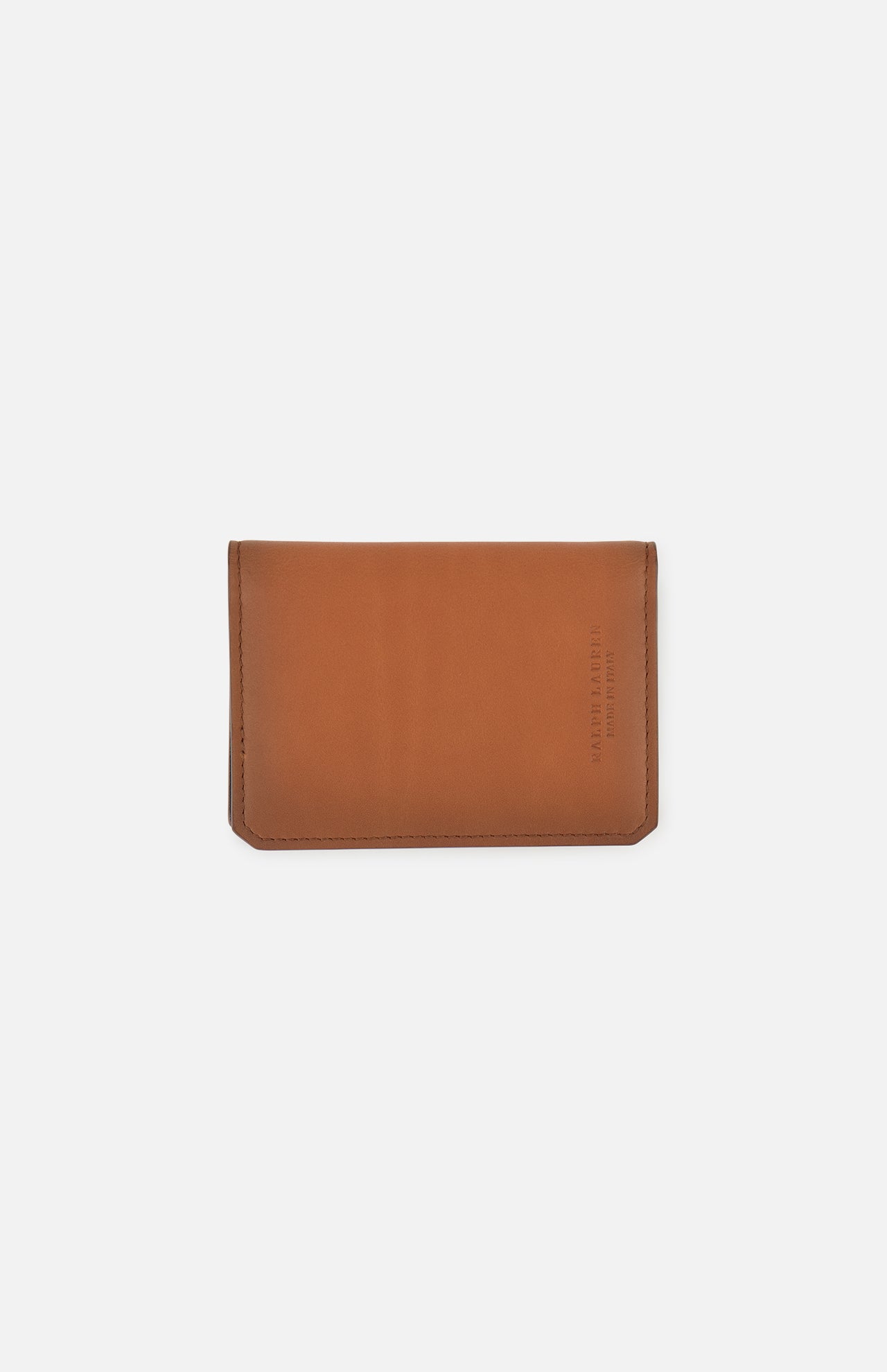 The Burnish Calf Wallet by RALPH LAUREN PURPLE LABEL is crafted from rich brown calfskin and showcases refined stitching with a minimalist silhouette. Subtle embossed text accents the lower right corner, while the piece is set against a plain white backdrop. Expertly made in Italy, this luxury card case exemplifies timeless elegance and superior craftsmanship.