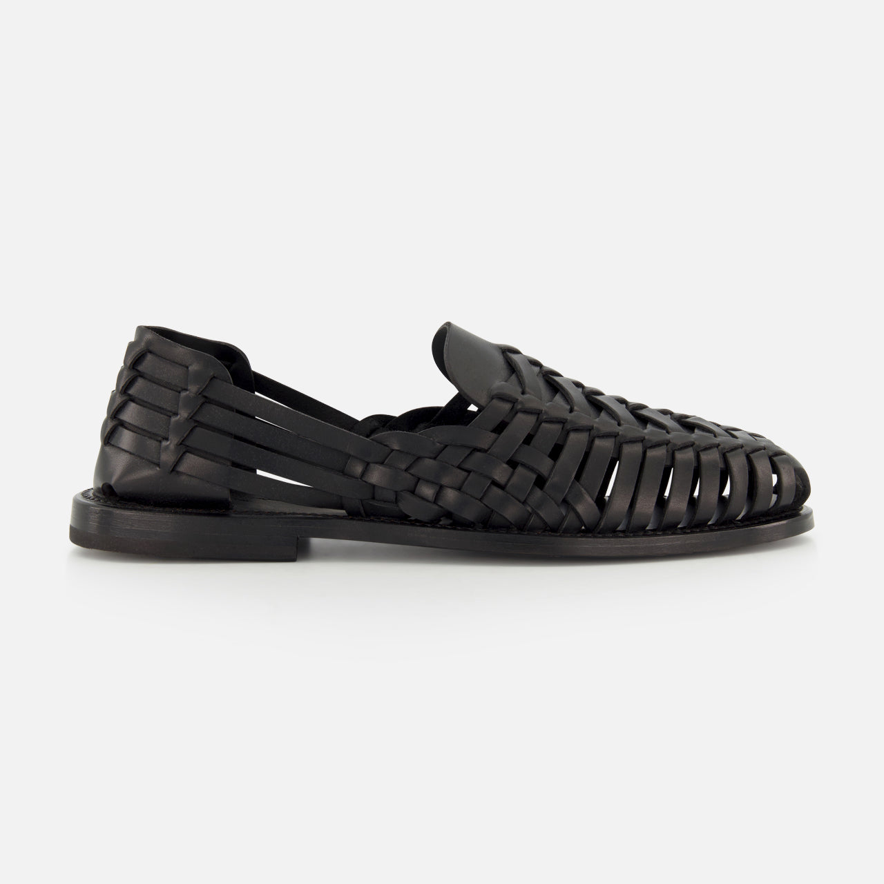 The Burnished Vacchetta Casual Loafer by RALPH LAUREN PURPLE LABEL, crafted in Italy from black woven leather with closed toe, open sides, and interlaced straps, features a flat sole and is displayed on a plain white background.