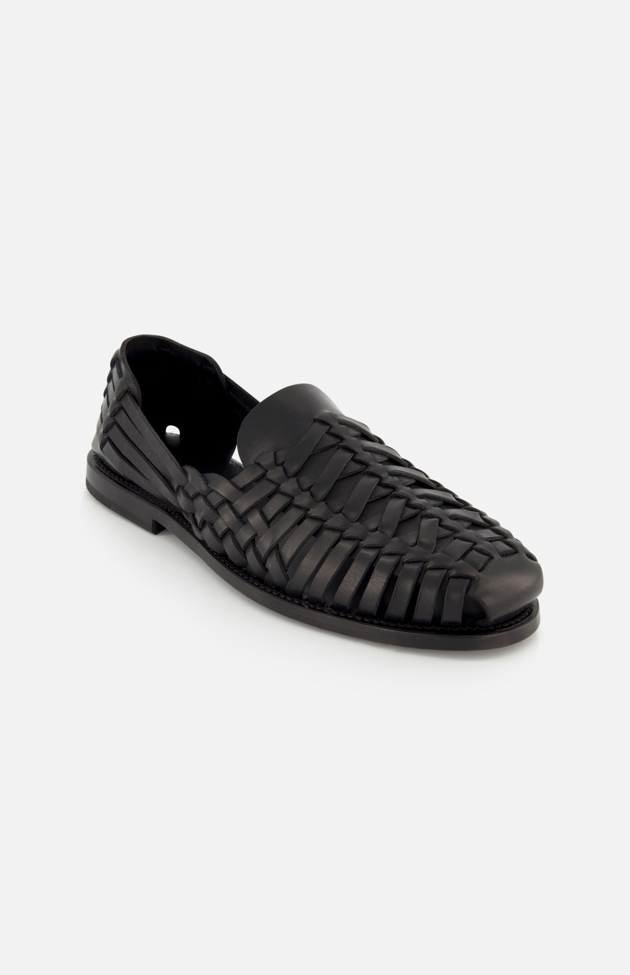 The Burnished Vacchetta Casual Loafer by RALPH LAUREN PURPLE LABEL is a black leather loafer with a woven design, closed toe, and low heel, crafted in Italy and shown on a plain white background.