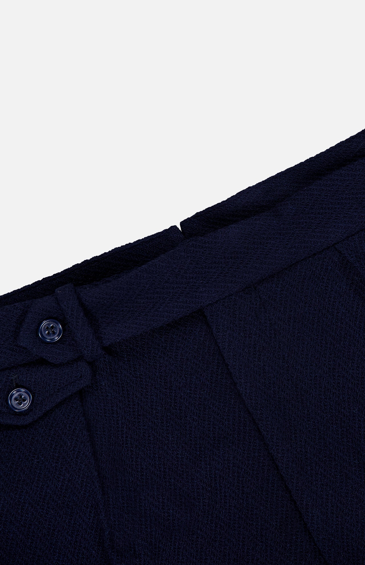 Close-up of the waistband of the RALPH LAUREN PURPLE LABEL Cashmere Herringbone Pleated Tennis Short in dark blue, featuring two buttons and a belt loop detail, set against a plain white background.