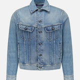 The Lux Italian Denim Trucker Jacket by RALPH LAUREN PURPLE LABEL features light blue Japanese denim with metal buttons, front chest pockets with flaps, side pockets, and visible seams. Showcasing a subtle vintage fade, this Purple Label jacket is displayed against a plain white background.