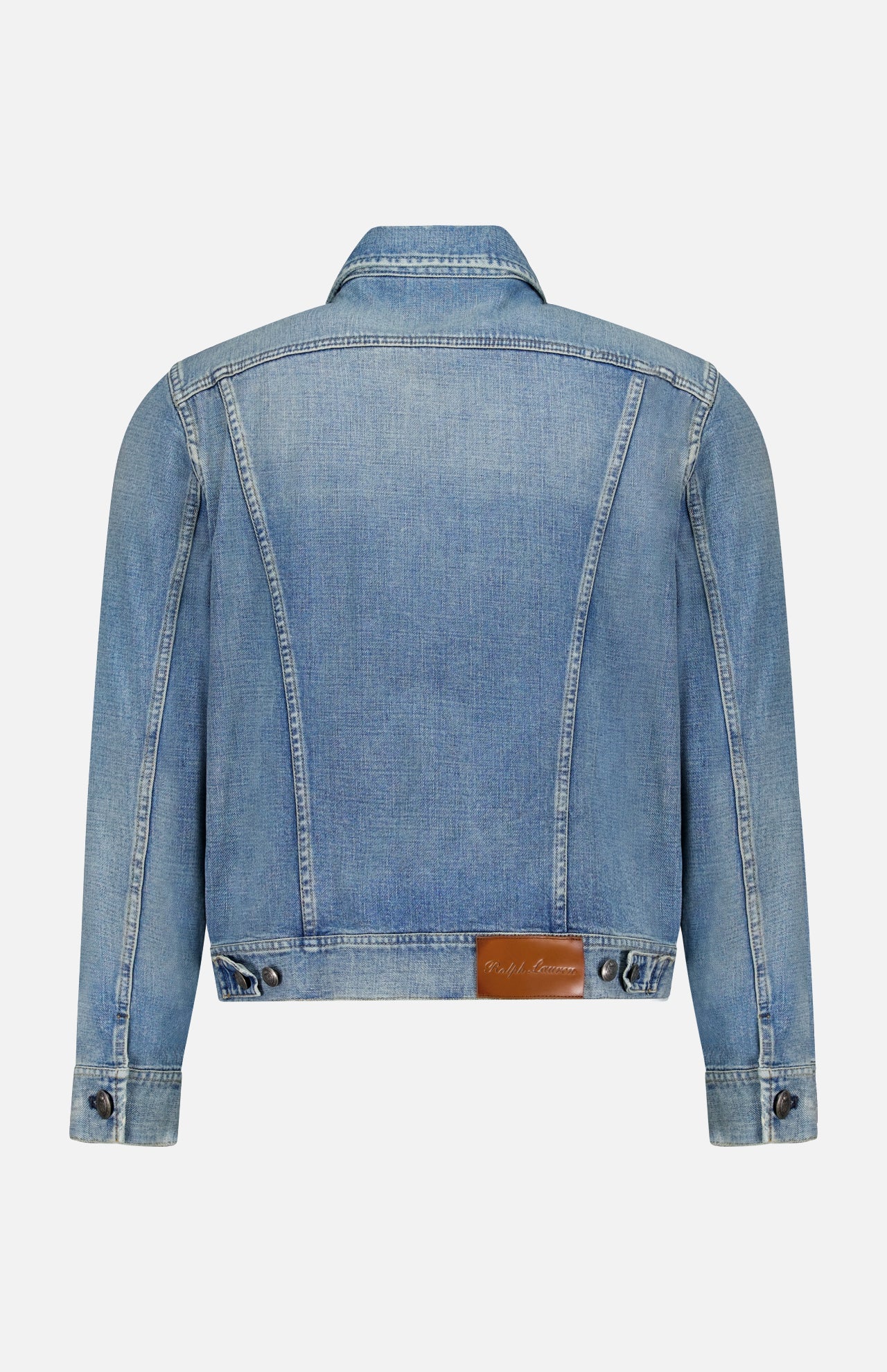 A light blue Lux Italian Denim Trucker Jacket by RALPH LAUREN PURPLE LABEL is shown from the back, featuring long sleeves, precise seam details, a folded collar, buttoned cuffs, adjustable waist tabs, and a brown leather patch near the waistband. The jacket presents a subtle vintage fade that highlights its timeless style.