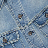 Close-up of the Lux Italian Denim Trucker Jacket from RALPH LAUREN PURPLE LABEL, featuring light blue Japanese denim with metal buttons, chest pockets, and prominent stitching details. A glimpse of the signature purple “RALPH LAUREN PURPLE LABEL” tag appears at the top left corner, accentuating the jacket’s subtle vintage fade.