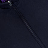 Close-up of the Double Faced Cashmere Felton Bomber Jacket, a luxury navy piece by RALPH LAUREN PURPLE LABEL, showcasing a prominent zipper and a purple Ralph Lauren label sewn inside the collar.