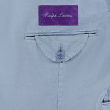 Close-up of the inner pocket of the Garment Dyed Cotton Single Breasted Sportcoat by RALPH LAUREN PURPLE LABEL, showcasing a curved flap with a button and crafted from stretch chino fabric. Above the pocket, a purple label with “Ralph Lauren” in white script highlights the vintage character of this hand-tailored Italian jacket.