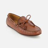The Harold Hand Burnished Tassle Loafer by RALPH LAUREN PURPLE LABEL is a single brown loafer crafted from luxurious French box calfskin, featuring a classic tassel detail on top, visible stitching, and an easy slip-on design, displayed on a white background.