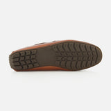 The image displays the bottom sole of the Harold Hand Burnished Tassle Loafer by RALPH LAUREN PURPLE LABEL, featuring a brown leather upper and a black, patterned rubber tread shown facing upward against a plain white background.