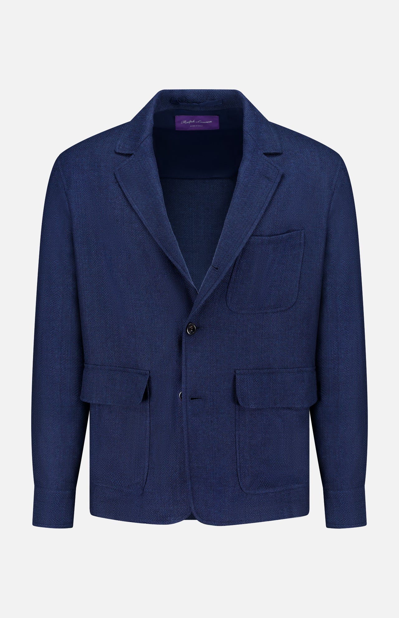 The Herringbone Single Breasted Sportcoat from RALPH LAUREN PURPLE LABEL is an Italian hand-tailored jacket in navy blue, featuring a notched lapel, one chest pocket, two front flap pockets, and a two-button front closure. The sportcoat is expertly crafted and displayed against a white background.