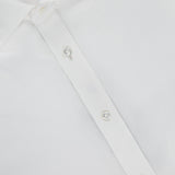 Close-up of the Journey Twill Long Sleeve Dress Shirt by RALPH LAUREN PURPLE LABEL, crafted from soft white cotton twill with pearl-like buttons and a visible collar. A purple label at the neck reads Ralph Lauren Made in Italy. The shirt appears clean and neatly pressed.