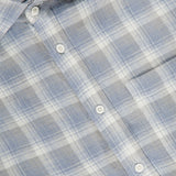 Close-up of a light blue, gray, and white plaid button-up shirt with a visible front pocket and collar. The label inside the collar reads RALPH LAUREN PURPLE LABEL. This Linen Twill Plaid Sport Shirt features pure linen construction, refined craftsmanship, and classic style—an ideal choice for those seeking a timeless men’s Italian shirt.