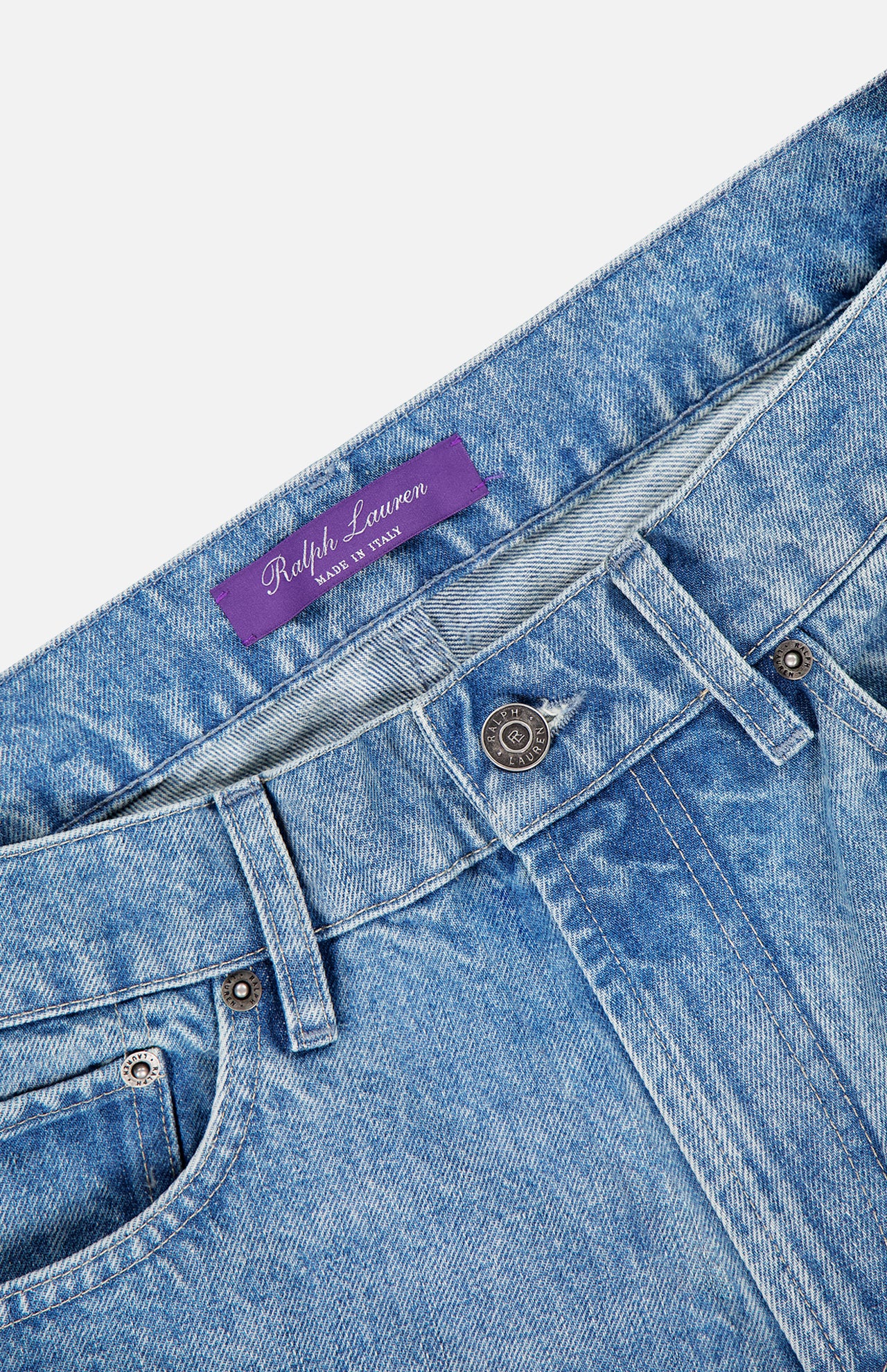 Close-up of the waistband on RALPH LAUREN PURPLE LABEL Lux Italian Denim Full Length Straight Jeans, featuring a purple label, metallic button closure, front belt loops, and a partially visible front pocket. Made in Italy, straight-leg fit.