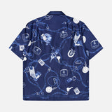 The RALPH LAUREN PURPLE LABEL Printed Silk Short Sleeve Sport Shirt is crafted in Italy from smooth navy silk and features a short-sleeve, button-up silhouette. Adorned with a pattern of white and light blue keys, wallets, coins, watches, and monogrammed logos, this luxury sport shirt is shown from the back against a plain white background.