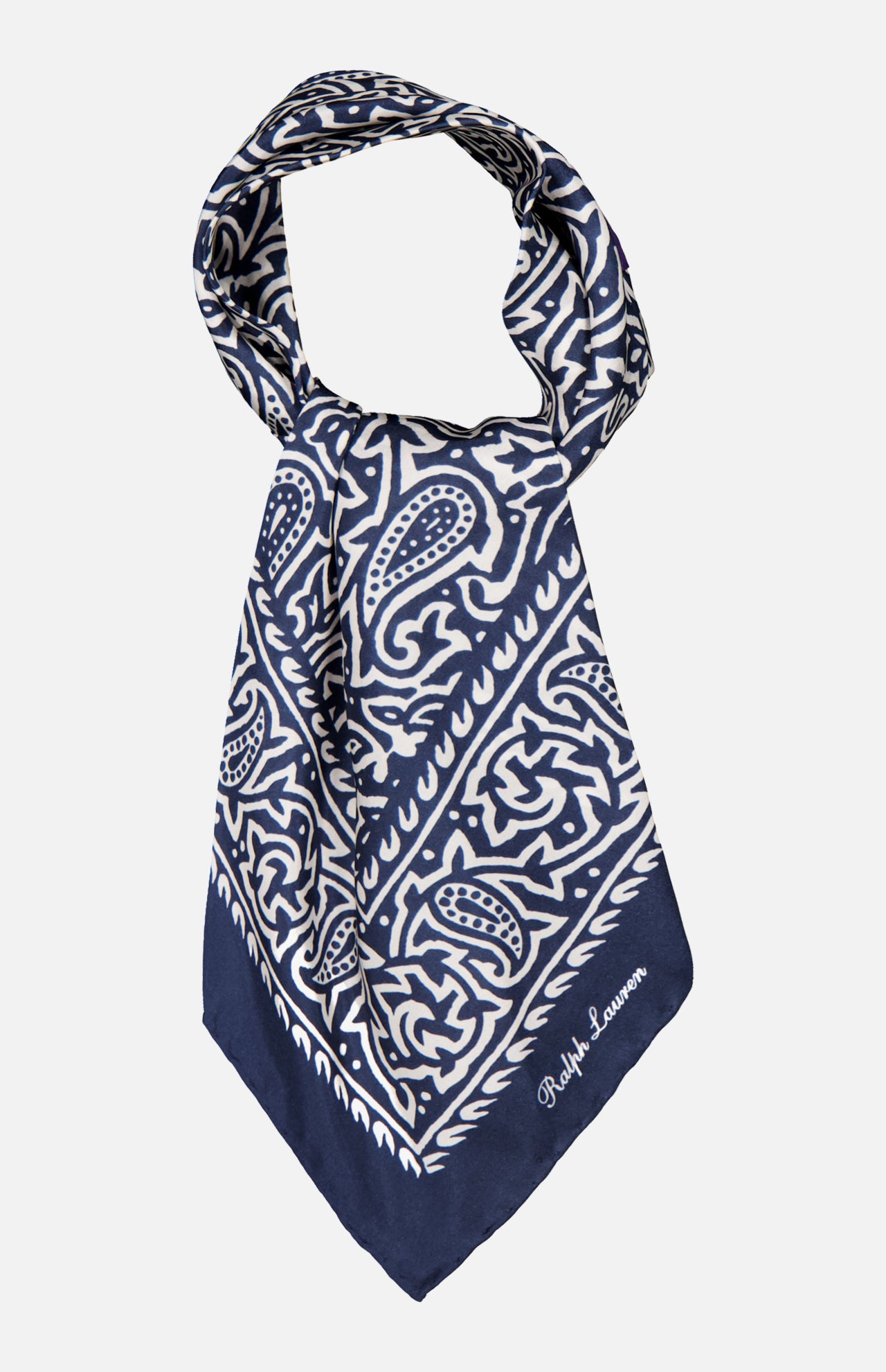 A navy blue and white Silk Choppa Scarf from RALPH LAUREN PURPLE LABEL, featuring intricate paisley and geometric patterns and folded into a triangle. Made in Italy from fine silk as a neckerchief, it is finished with "Ralph Lauren" embroidered in white on one corner.