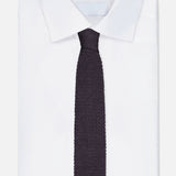 A neatly folded white dress shirt with a pointed collar is paired with the RALPH LAUREN PURPLE LABEL Superknit Silk Tie, crafted in Italy, and displayed on a plain white background.